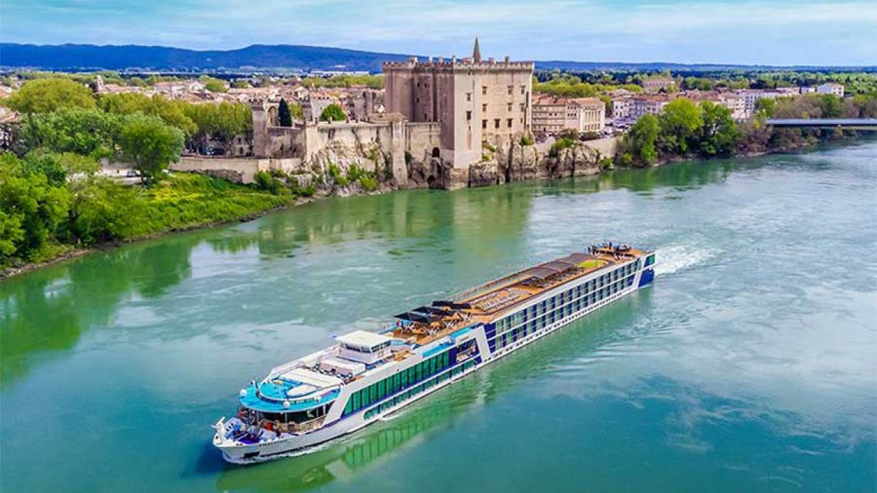 River cruise ship sailing past a riverside château